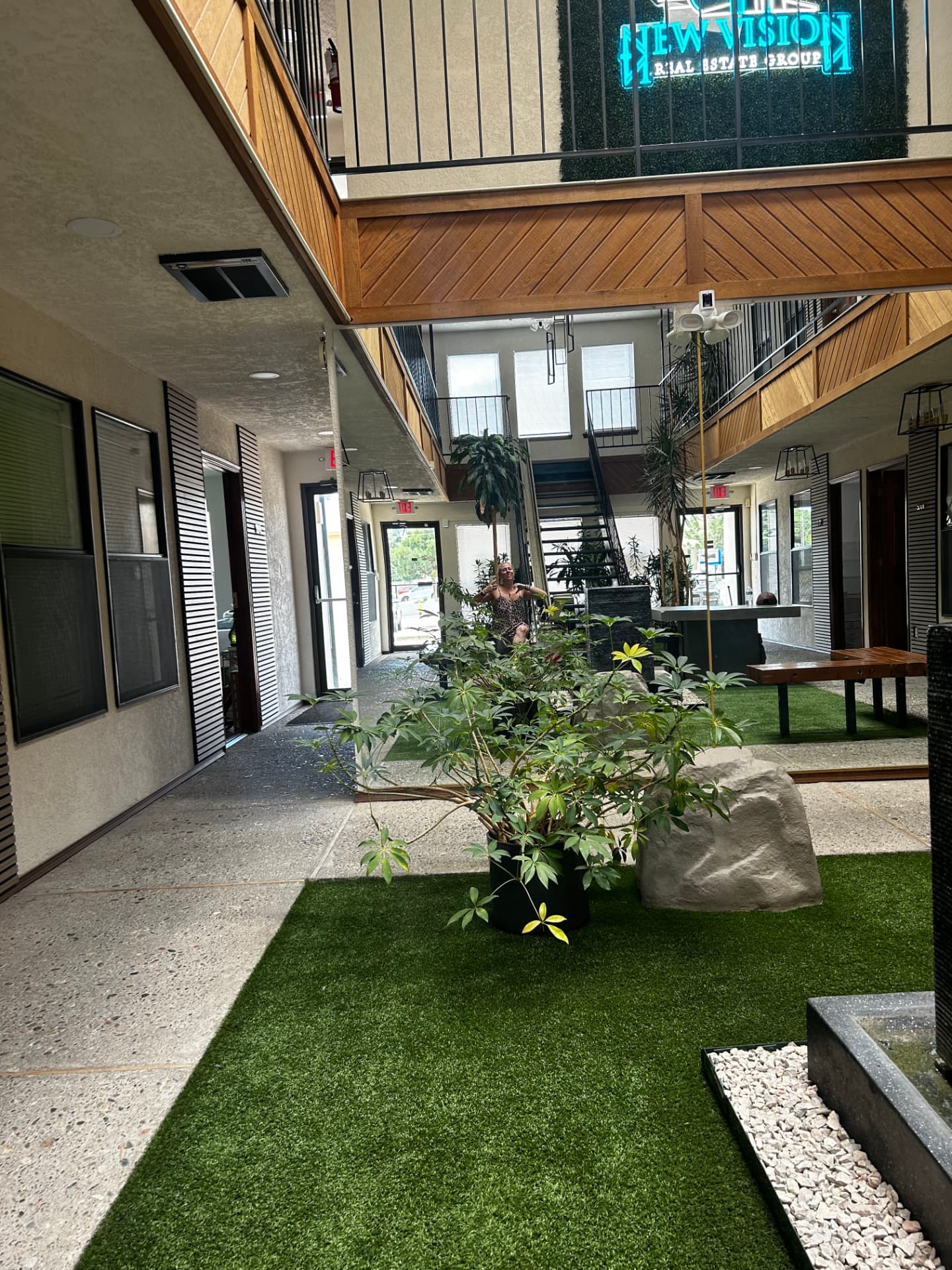 Serene atrium sanctuary entrance with plants, boulders, and natural light leading into the studio